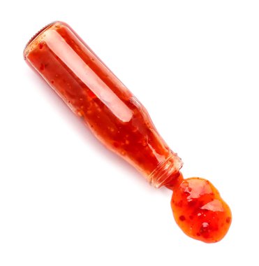 Beyaz arka planda dökülmüş kırmızı biber soslu bir şişe.