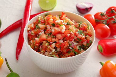 Beyaz arka planda bir kase lezzetli salsa sosu.