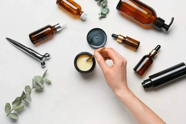 Main Féminine Avec Différents Produits Cosmétiques Sur Fond Clair — Photo