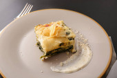 Talíř s lahodnými zelenými lasagne na stole, detailní záběr