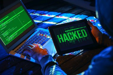 Hacker karanlık odada bilgisayar kullanıyor.