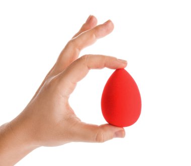 Beyaz arka planda makyaj süngeri olan bir kadın el.