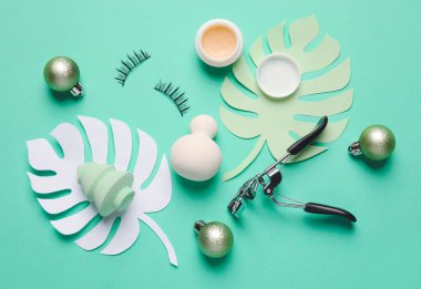 Renk arkaplanında makyaj malzemeleriyle Noel kompozisyonu