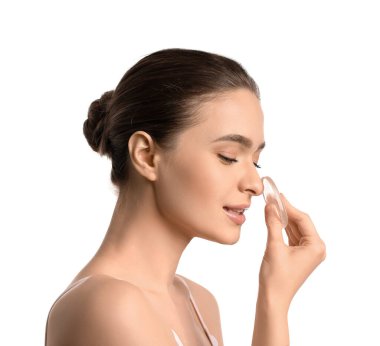 Beyaz arka planda makyaj süngeri olan güzel bir genç kadın.