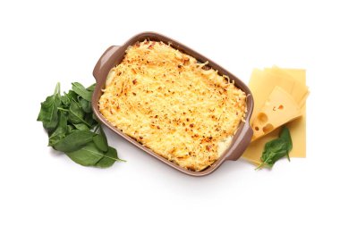 Lezzetli yeşil lazanyalı fırın yemeği ve beyaz arka planda malzemeler.