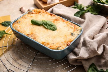 Grunge arka planında lezzetli yeşil lazanyalı fırın yemeği.