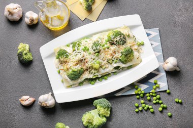 Lezzetli yeşil lazanyalı kompozisyon ve koyu arkaplanda malzemeler