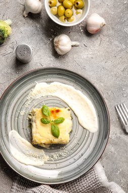 Lezzetli yeşil lazanya tabağı ve grunge arkaplanda malzemeler.