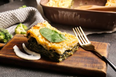 Koyu arkaplanda lezzetli yeşil lazanya olan tahta