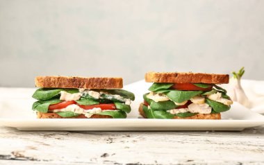 Hafif arka planda lezzetli sandviçli tabak.