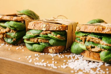 Renkli arka planda lezzetli sandviçleri olan tahta, yakın plan