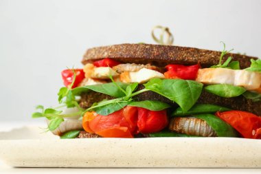 Hafif arka planda lezzetli sandviçli tabak, yakın plan.