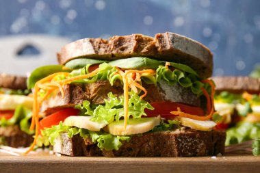 Renkli arka planda lezzetli sandviçi olan tahta, yakın plan