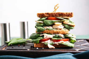 Hafif arka planda lezzetli sandviçi olan tahta, yakın plan