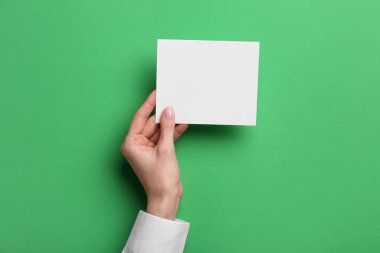 Renk arkaplanı üzerine boş kağıt tutan kadın