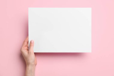 Renk arkaplanı üzerine boş kağıt tutan kadın, yakın plan