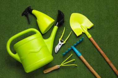 Renk arkaplanı üzerinde sulama kutusu ve bahçe araçları