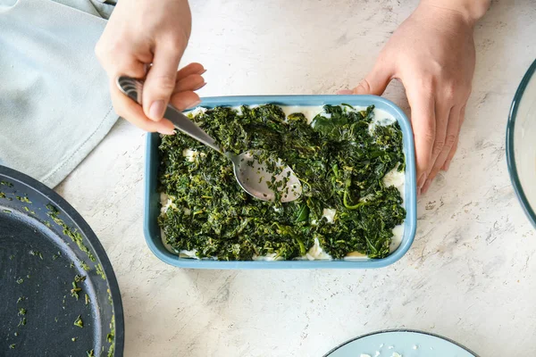 Vrouw Bereidt Smakelijke Groene Lasagne Lichte Achtergrond — Stockfoto