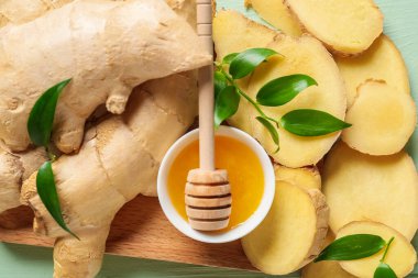 Dilimlenmiş taze zencefil ve masada bal.