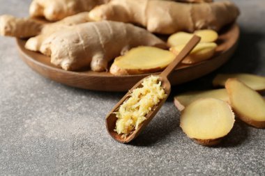 Taze rendelenmiş zencefilli kepçe ve koyu arkaplanda dilimler