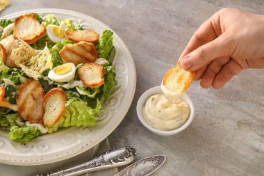 Arka planda lezzetli Sezar salatası yiyen kadın, yakın plan.