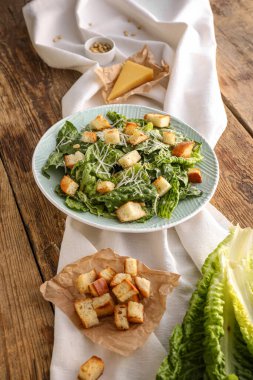 Ahşap arka planda lezzetli Sezar salatası tabağı