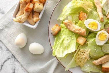 Hafif arka planda lezzetli Sezar salatası tabağı, yakın plan.