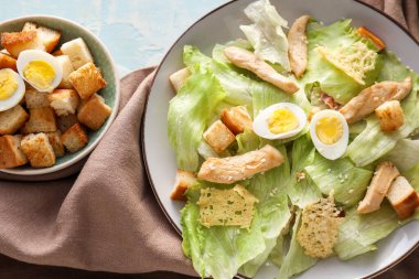 Renkli arka planda lezzetli Sezar salatası tabağı, yakın plan.