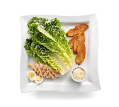 Beyaz arkaplanda Sezar salatası için malzemeler