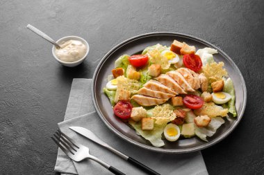 Lezzetli Sezar salatası ve koyu arkaplanda sos.