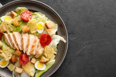 Koyu arkaplanda lezzetli Sezar salatası.