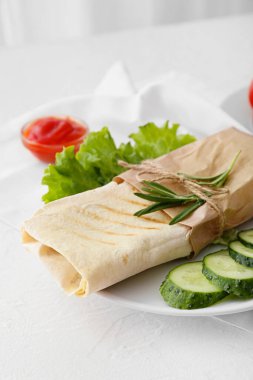 Hafif arka planda lezzetli donör kebap ve sebzeli tabak, yakın plan.