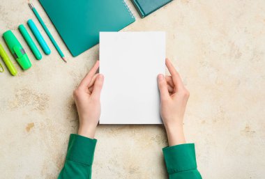 Grunge arka planında boş kağıt ve kırtasiye malzemesi olan kadın elleri