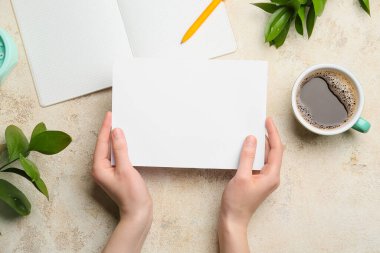 Boş kâğıt, defter, kalem ve kahve fincanı olan kadın elleri.