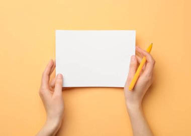 Arkaplanda boş kağıt ve kalem tutan kadın