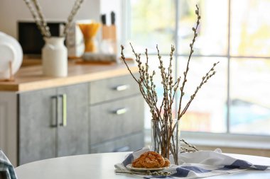 Mutfaktaki masada söğüt dalları olan vazo.