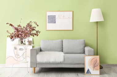 Oturma odasının içindeki masada çiçek açan dalları olan vazo.