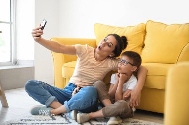 Genç kadın ve küçük oğlu evde selfie çekiyorlar.