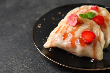 Koyu arka planda lezzetli çilekli börek tabağı, yakın plan.