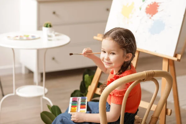 Cute little artist painting at home