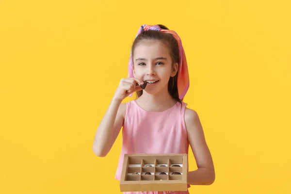 Cute Little Girl Jedzenie Czekoladowe Cukierki Tle Koloru — Zdjęcie stockowe