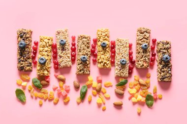 Healthy cereal bars, berries and nuts on color background clipart