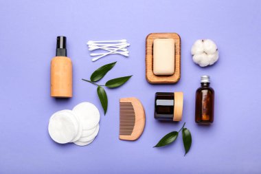 Renk arkaplanına pamuk pedleri, çubuklar, tarak ve kozmetik ürünler ile kompozisyon