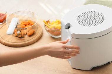 Mutfakta fritöz kullanan genç bir kadın, yakın plan.