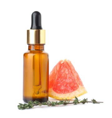 Beyaz arka planda bir şişe gerekli yağ ve greyfurt dilimi.