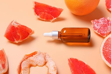 Renkli arka planda gerekli yağ ve greyfurt şişesi