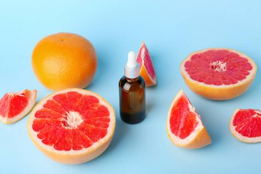 Renkli arka planda gerekli yağ ve greyfurt şişesi