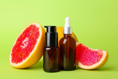 Renkli arka planda gerekli yağ ve greyfurt şişeleri