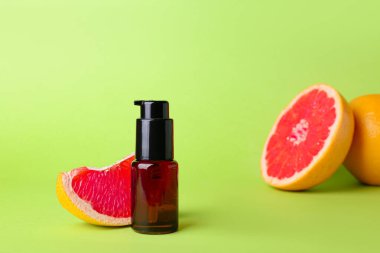 Renkli arka planda gerekli yağ ve greyfurt şişesi