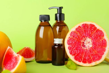 Renkli arka planda gerekli yağ ve greyfurt şişeleri